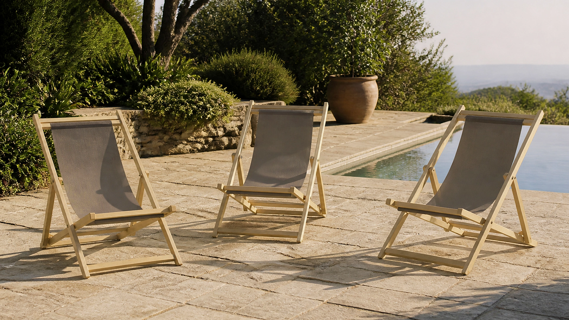 Tre sdraio Portofino Toscano Forme in frassino naturale su una terrazza mediterranea con piscina