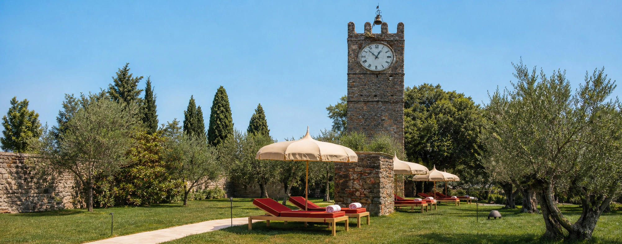 Toskanischer Garten mit historischem Turm, Sonnenschirmen und Liegen von Toscano Forme
